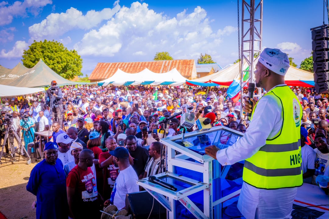 Barji addressing a large crowd from the podium