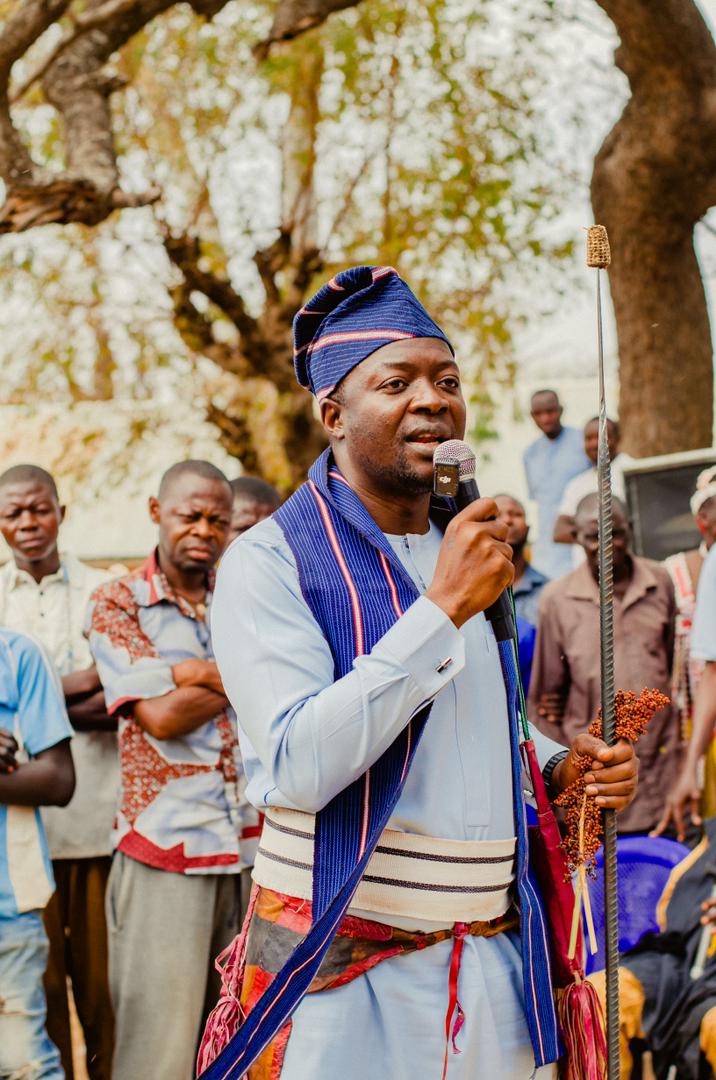 Barji addressing a crowd with the ceremonial staff
