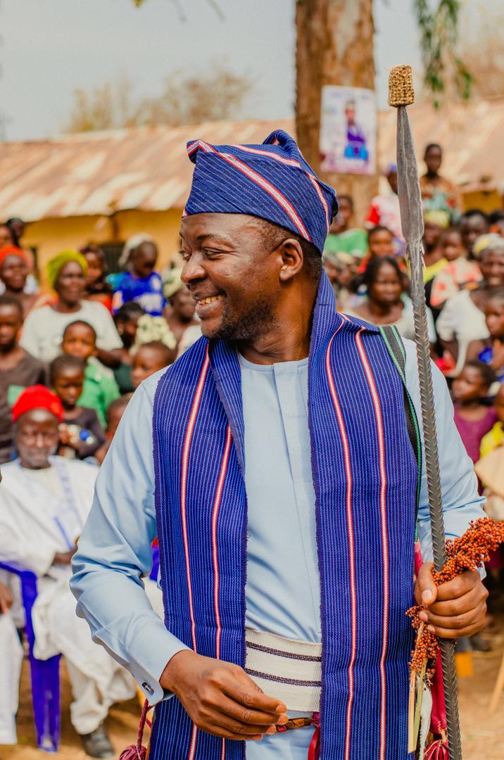 Barji smiling, holding the ceremonial staff