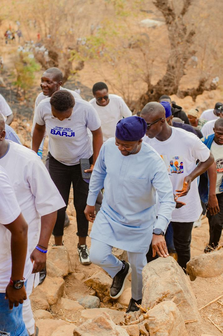 Barji walking with supporters on a hillside